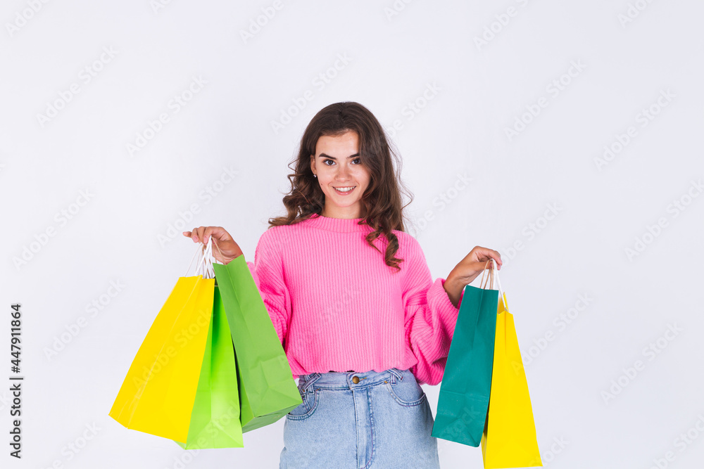 Young beautiful woman with freckles light makeup in sweater on white background with shopping bags happy cheerful smiling Young beautiful woman with freckles light makeup in sweater on white background with shopping bags happy cheerful smiling