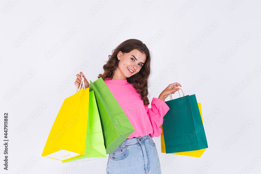 Young beautiful woman with freckles light makeup in sweater on white background with shopping bags happy cheerful smiling