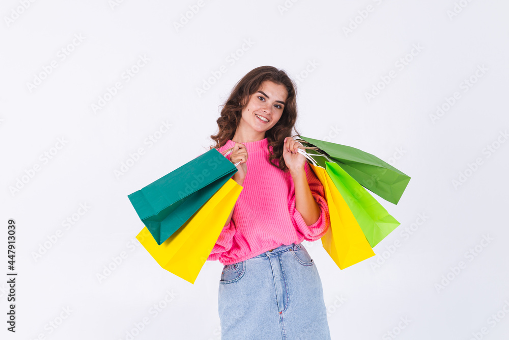 Young beautiful woman with freckles light makeup in pink sweater and jeans skirt on white background stylish hold shopping bags Young beautiful woman with freckles light makeup in pink sweater and jeans skirt on white background stylish hold shopping bags