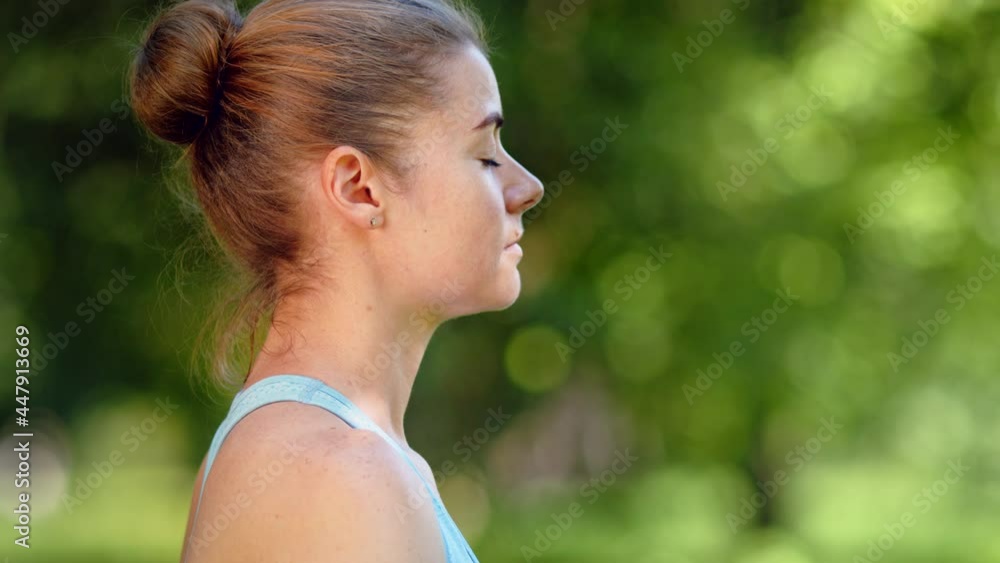 Calm young woman blonde relaxes in yoga pose against park Calm young woman blonde relaxes in yoga pose against park