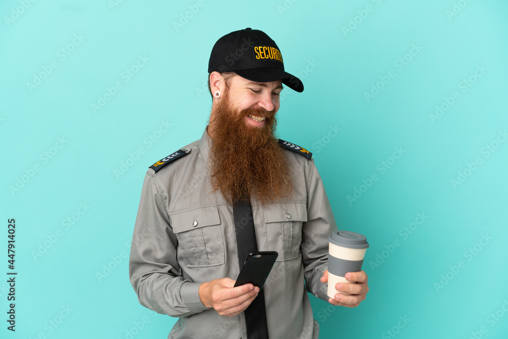 Redhead security man isolated on white background holding coffee to take away and a mobile