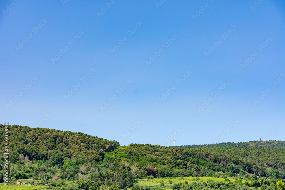 Scenic lush green landscape wth forested hills or mountains