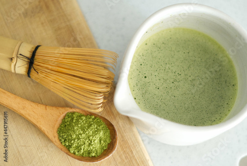 Mixing matcha with wooden spoon and chasen whisk in chawan bowl.