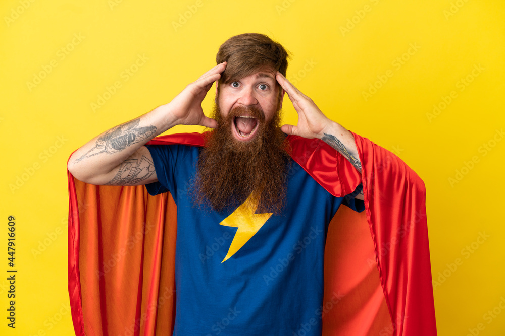 Redhead Super Hero man isolated on yellow background with surprise expression Redhead Super Hero man isolated on yellow background with surprise expression