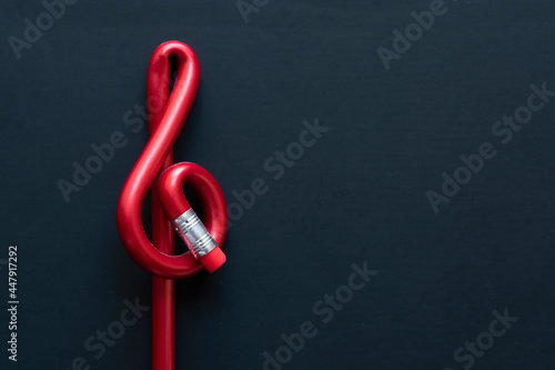 Red pen with treble form on black background