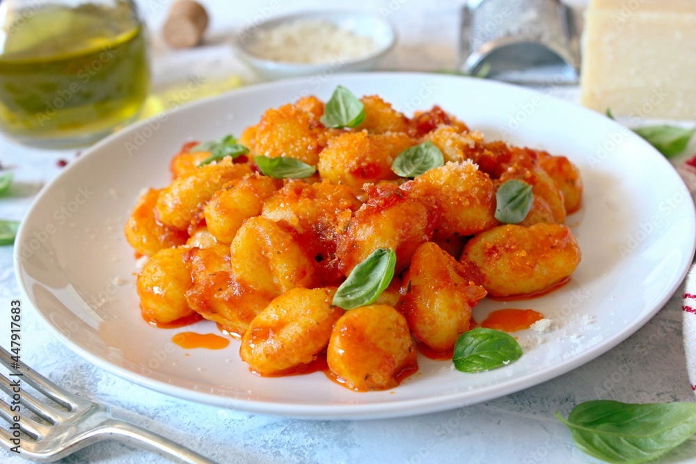 Traditional Italian potato gnocchi with tomato sauce, parmesan cheese and fresh basil. Top view. Traditional Italian potato gnocchi with tomato sauce, parmesan cheese and fresh basil. Top view.