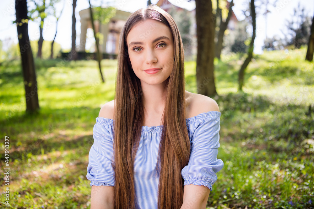 Portrait of attractive peaceful girl sitting on fresh air green grass resting at downtown outdoors Portrait of attractive peaceful girl sitting on fresh air green grass resting at downtown outdoors