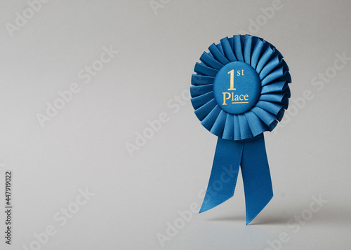 Fotografija Blue rosette first place on a gray background as a reward for achievement, success and victory