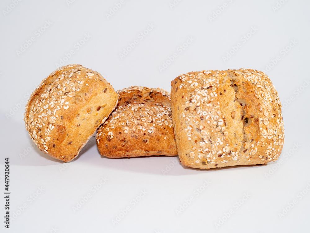 Baked bun soaked in sesame seeds and oatmeal isolated on white background.