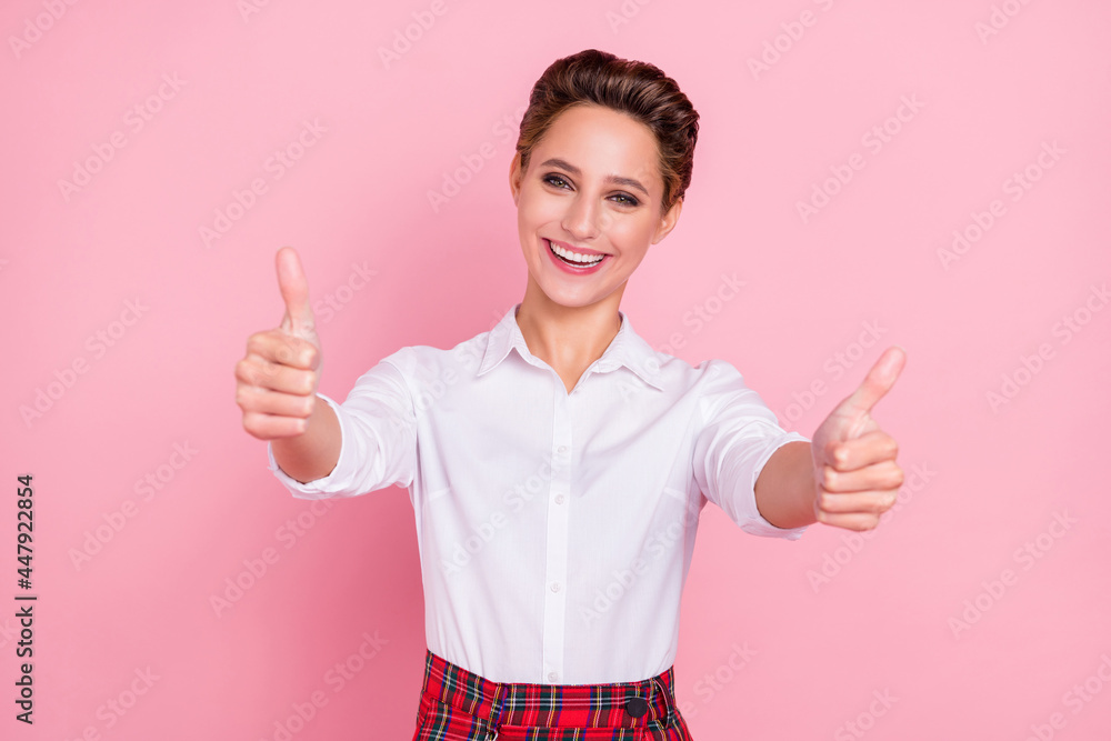Photo of nice blond millennial lady thumb up wear white shirt isolated on pink color background Photo of nice blond millennial lady thumb up wear white shirt isolated on pink color background