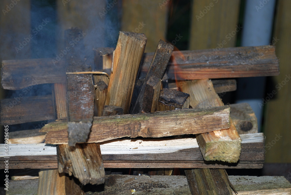 Pine firewood is stacked in a square for a fire. Several pieces of wood are stacked in a square fire tower in the middle of the tower, other firewood is stacked vertically. Pine firewood is stacked in a square for a fire. Several pieces of wood are stacked in a square fire tower in the middle of the tower, other firewood is stacked vertically.