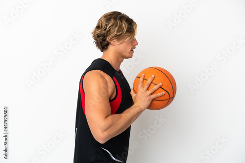 Young blonde man isolated on white background playing basketball