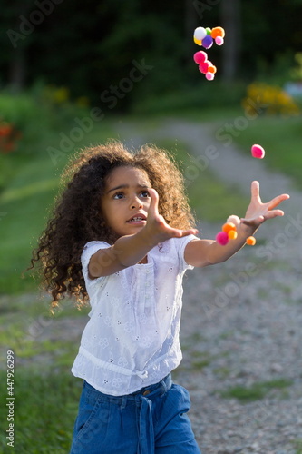 grey  forests  trees  misty  day    Vertical view of beautiful excited little girl in summer clothes jumping with intent expression to catch colourful pompoms  Quebec City  Quebec  Canada