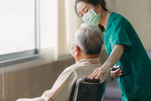 Bilde på lerret Young Asian woman nurse explaining information to elderly man patient in wheelchair with friendly smiley face in the hospital