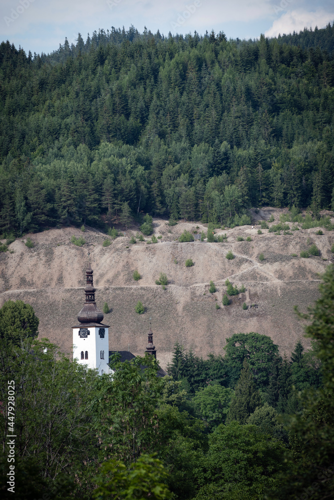Tower of Spania Dolina church surrounded by trees, Slovakia