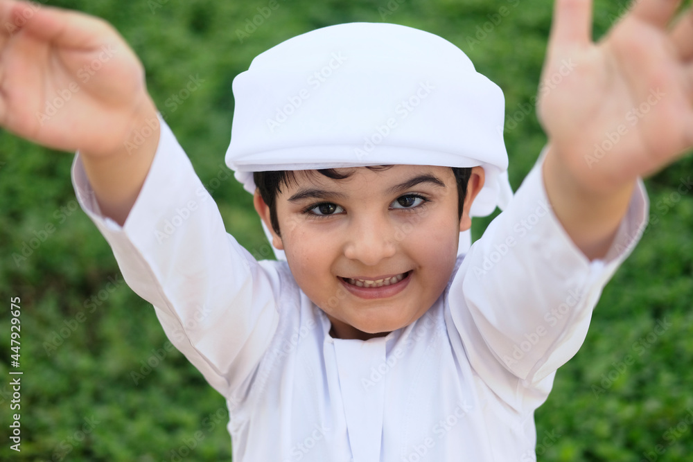 Middle East child on Kandura. Happy Emirati kid having fun Middle East child on Kandura. Happy Emirati kid having fun
