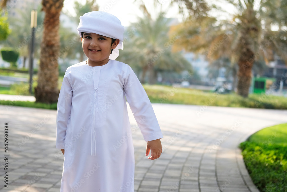 Middle East child on Kandura. Happy Emirati kid having fun Middle East child on Kandura. Happy Emirati kid having fun