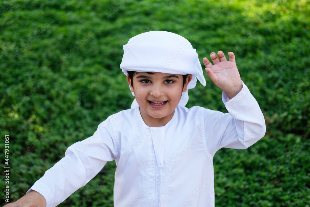 Middle East child on Kandura. Happy Emirati kid having fun Middle East child on Kandura. Happy Emirati kid having fun