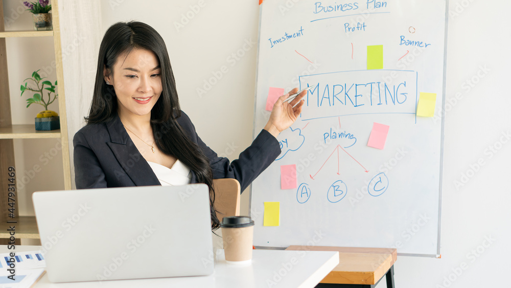 Young Asian businesswoman working on laptop and analyzing financial accounting graphs in home office Young Asian businesswoman working on laptop and analyzing financial accounting graphs in home office