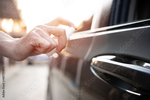 Close up hand women use Alcohol spray clean hand opening the car door protection and cleaning concept of transportation