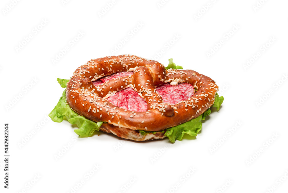 Pretzel with salami and lettuce isolated on a white background. Pretzel with salami and lettuce isolated on a white background.