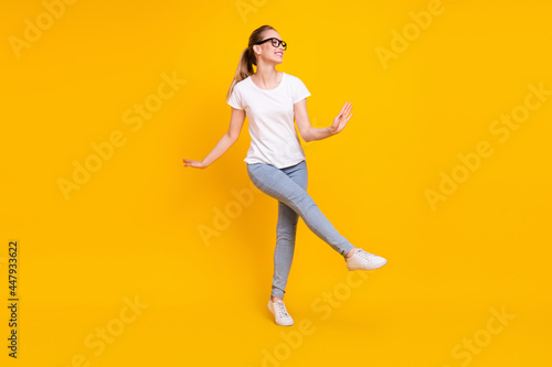 Full length profile side photo of young woman happy positive smile have fun dance isolated over yellow color background