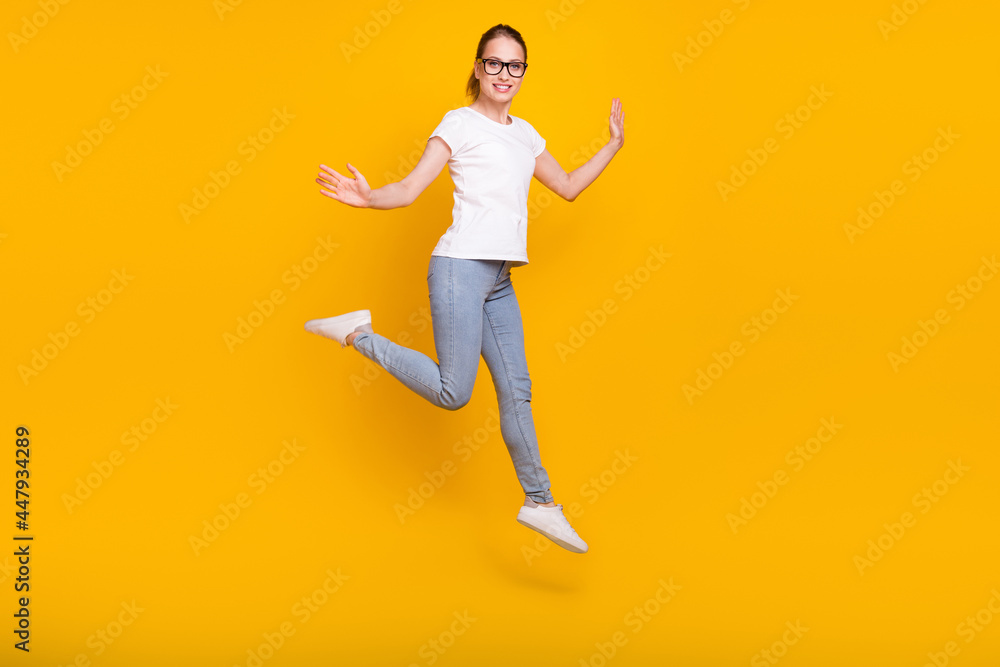 Full length photo of young woman happy positive smile jump active isolated over yellow color background