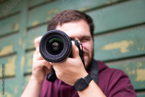 Half length of young beautiful man outdoor in the city holding digital camera, shooting - photography, creative, artist concept 