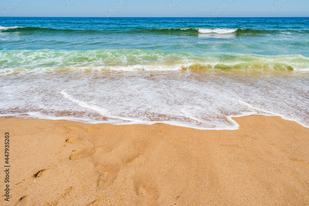 Waves of the Atlantic Ocean moving and crashing on the sand, colorful seascape PORTUGAL Waves of the Atlantic Ocean moving and crashing on the sand, colorful seascape PORTUGAL