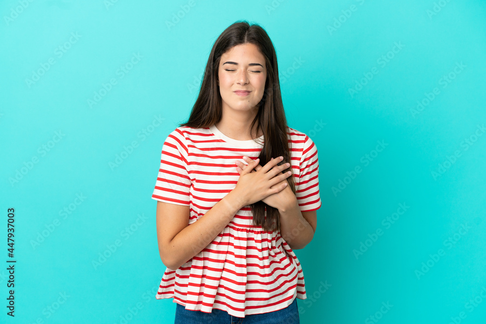 Young Brazilian woman isolated on blue background having a pain in the heart