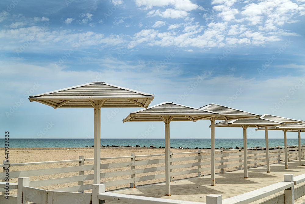 Thatched sun umbrellas on the sandy beach