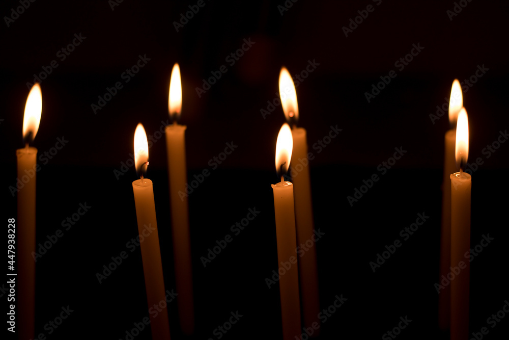 Several candles lit in the dark for religious purposes. Several candles lit in the dark for religious purposes.