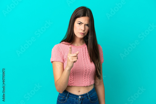 Young Brazilian woman isolated on blue background frustrated and pointing to the front