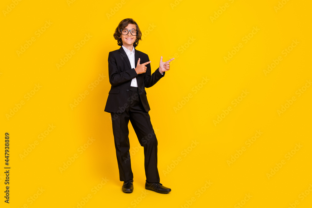 Obraz premium Photo of promoter little boy direct forefinger empty space wear specs black uniform isolated yellow color background