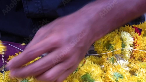 Steady footage of a man making garland and decorative braid knot or a wreath of flowers, leaves, or other material.
 photo