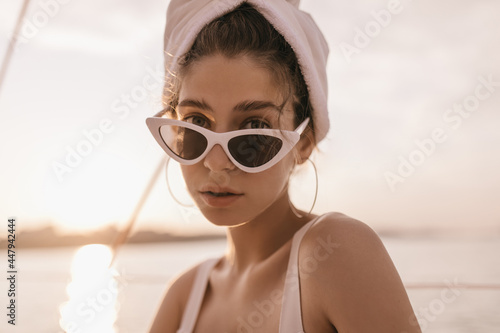 Photography Stylish girl with light hair, blue eyes and thick eyebrows, in sunglasses and to
