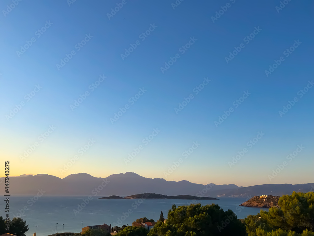 view of the island surrounded by mountains at sunset