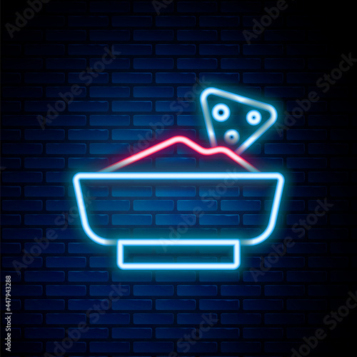 Glowing neon line Nachos in bowl icon isolated on brick wall background. Tortilla chips or nachos tortillas. Traditional mexican fast food menu. Colorful outline concept. Vector