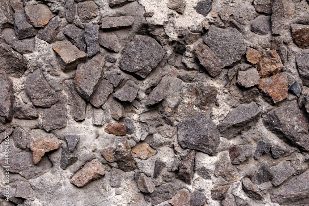 Fototapeta premium Stones embedded in the wall. Abstract background of stones