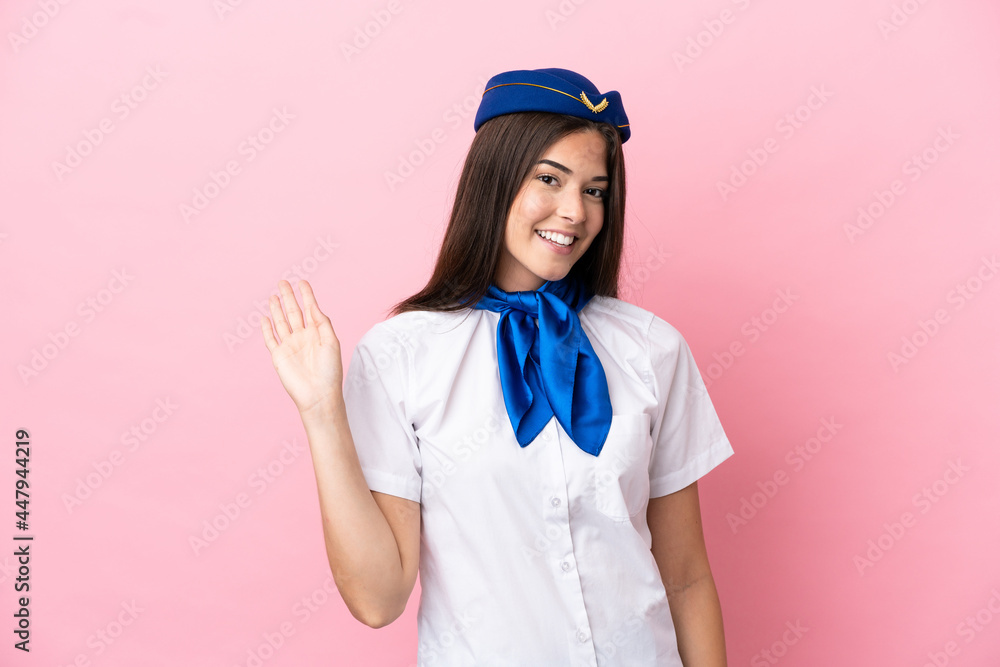 Airplane stewardess Brazilian woman isolated on pink background saluting with hand with happy expression Airplane stewardess Brazilian woman isolated on pink background saluting with hand with happy expression