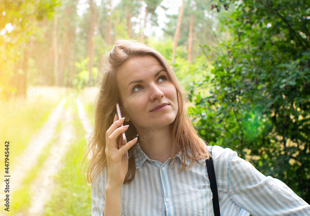Beautiful girl with fair hair is talking on phone in forest. Young woman lost on the nature. No signal phone connection. Beautiful girl with fair hair is talking on phone in forest. Young woman lost on the nature. No signal phone connection.