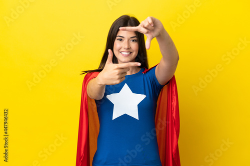 Super Hero Brazilian woman isolated on yellow background focusing face. Framing symbol © luismolinero