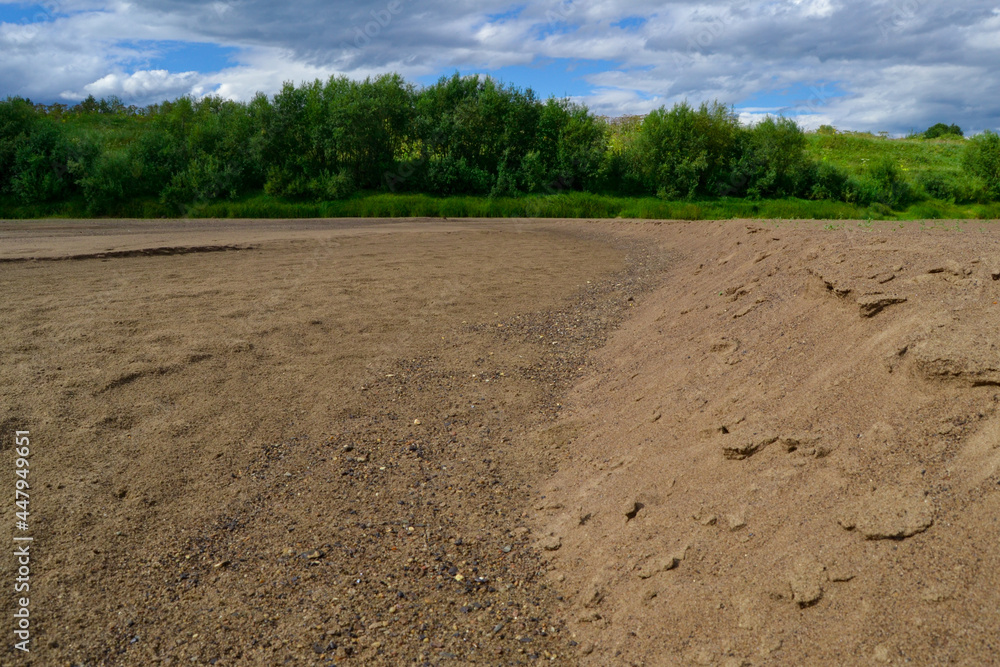 Large sandy beach. The forest in the distance. Dry river bed. Large sandy beach. The forest in the distance. Dry river bed.