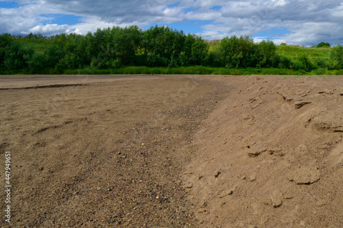 Large sandy beach. The forest in the distance. Dry river bed.