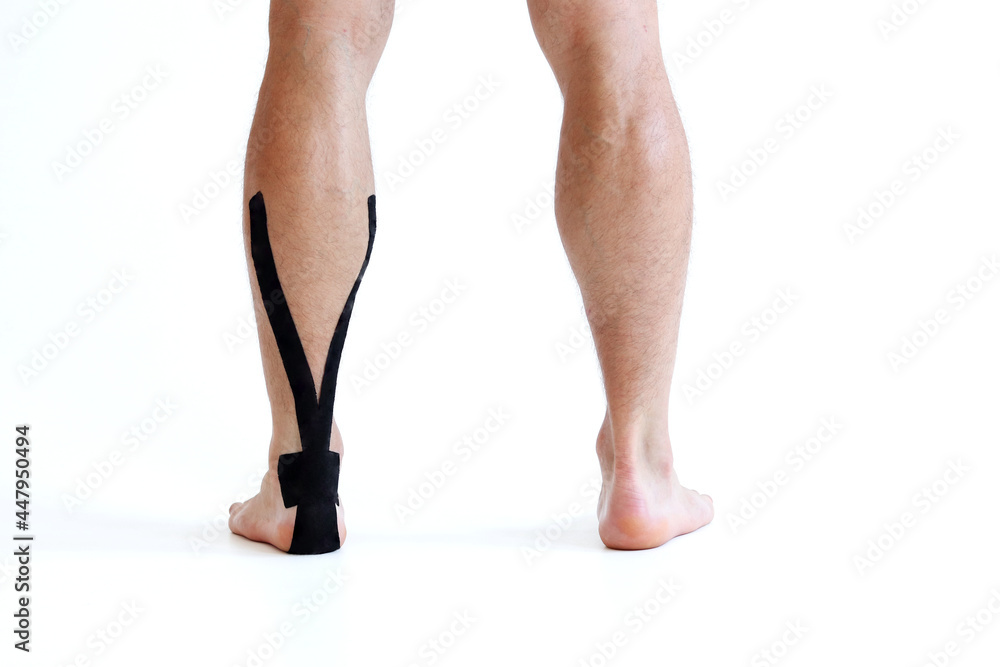 Kinesiology taping treatment with black tape on male patient injured