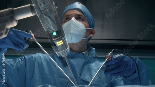 Obraz na plátně Team of surgeons perform a delicate operation using medical surgical robot while observing data on transparent screens