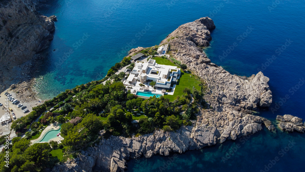 Naklejka premium Luxurious mansion on a private islet north of Ibiza island in Spain - Large property with a white villa along the Mediterranean Sea in the Balearic Islands