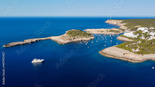 Aerial view of the bay of Portinatx on the north shore of Ibiza island in Spain - Yachts anchored near a sandy beach surrounded by pine forests and rocky cliffs in the Balearic Islands photo