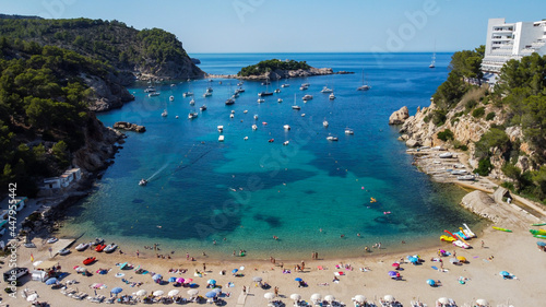 Aerial view of the beach of Port Sant Miquel on the north shore of Ibiza island in Spain - Isolated bay sided with large hillside hotels in the Balearic Islands photo