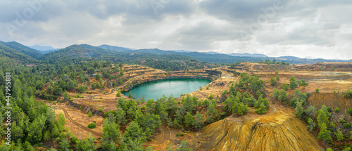 Restoration works in copper mining area with lake in open mine pit and spoil heaps covered with pine trees in Troodos mountains, Cyprus photo